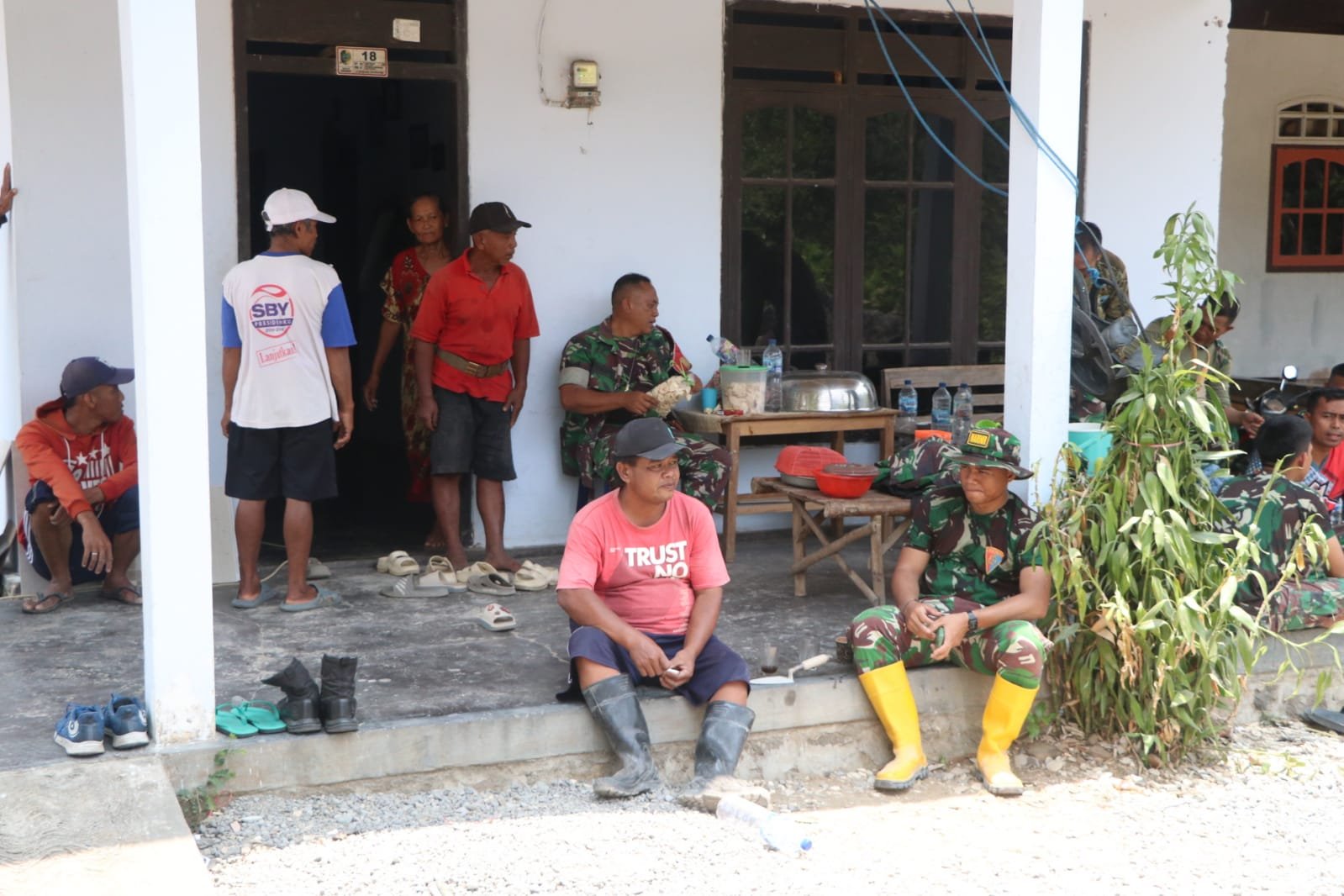 TNI dan Masyarakat Sama-sama Menikmati Hidangan Siang dalam Program TMMD